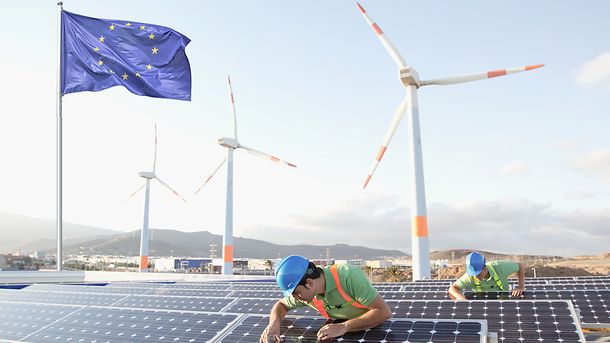 Bild von Arbeitern, die Sonnenkollektoren bei einem Plan für erneuerbare Energien inspizieren.|© Getty Images/LL28