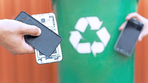 E waste , recycle concept , disassembled smartphone and recycle bin in background