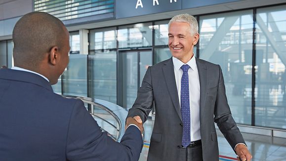 Businessmen handshaking in airport concourse