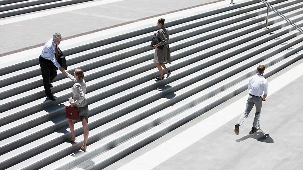 Business people shaking hands on steps outdoors