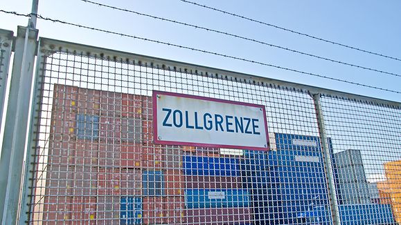 Stacheldraht Zaun mit Schild Zollgrenze vor Container Lagerplatz