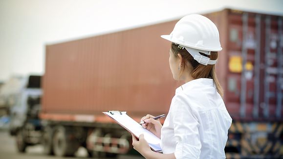 Weibliche Dockarbeiter kontrollieren das Laden der Containerbox in den LKW für den Logistic Import Export Hintergrund, Business-Logistikkonzept ©GettyImages/Thatree Thitivongvaroon