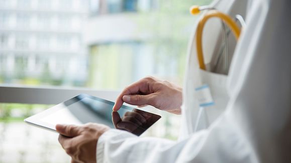 Doctor with a tablet in the hands and office background