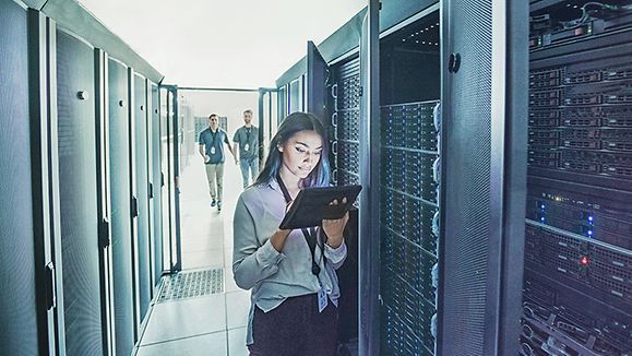 Frau mit Laptop vor Datenservern