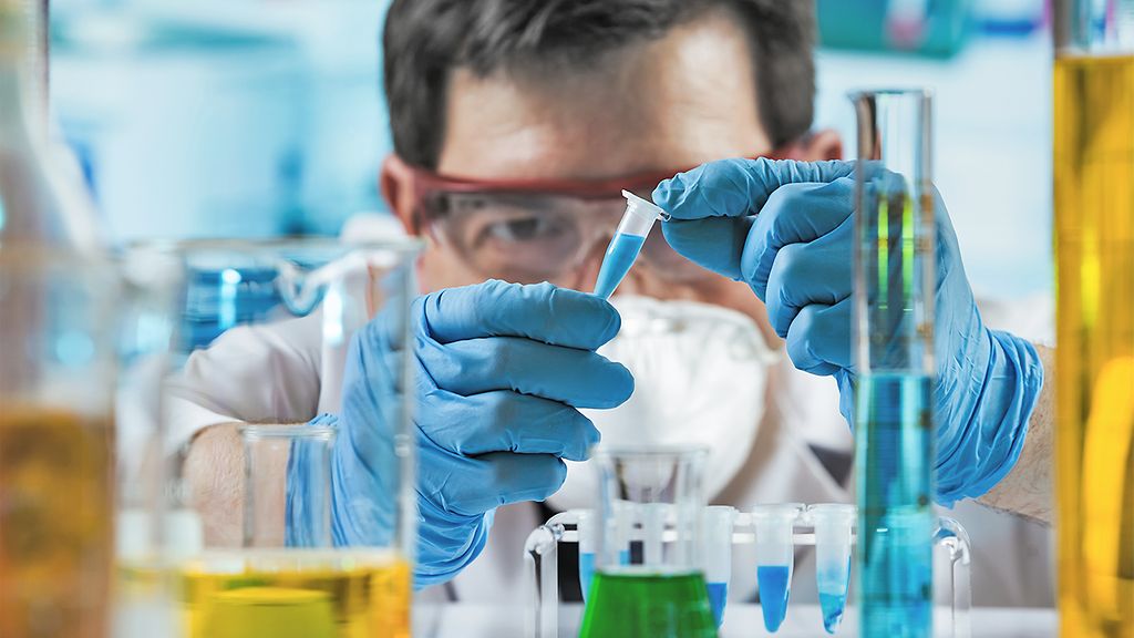 Chemist engineer holding test tube in the investigation lab / Researcher holding tube pcr in the laboratory