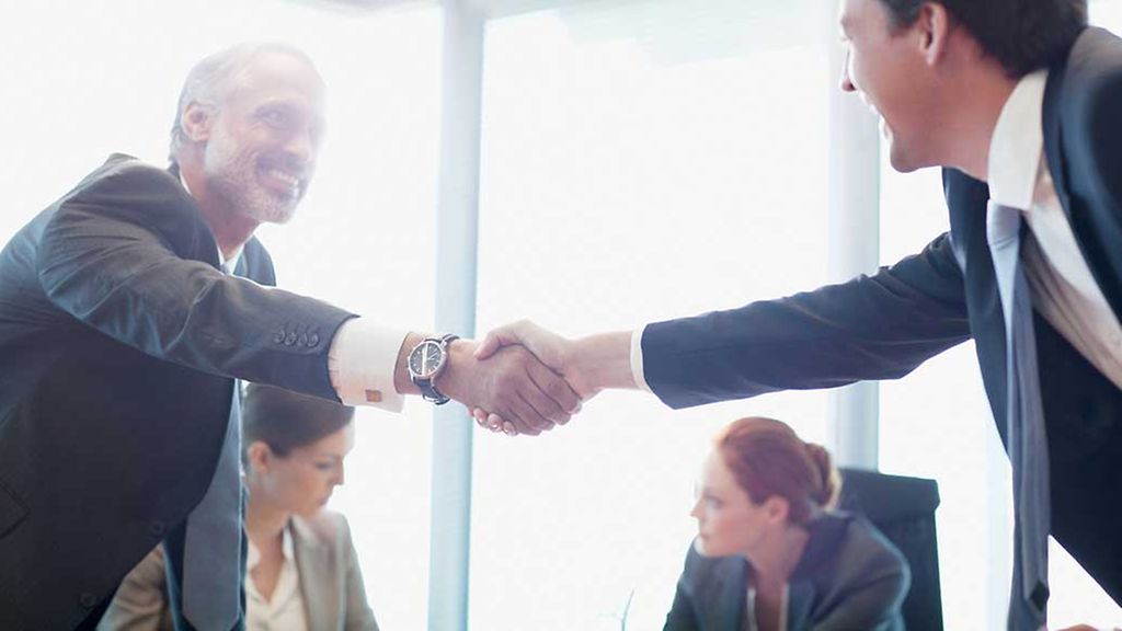 Businessmen shaking hands in conference room